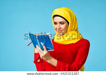     arab woman writing in notebook on a blue background                          