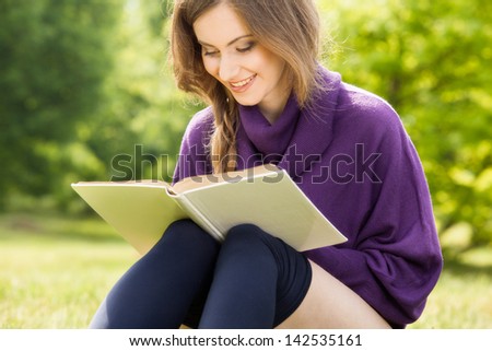 Beautiful girl reading a book and relax in the park