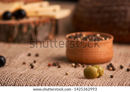 olive is on the table in background of bread, baguette and cheese. Selective focus