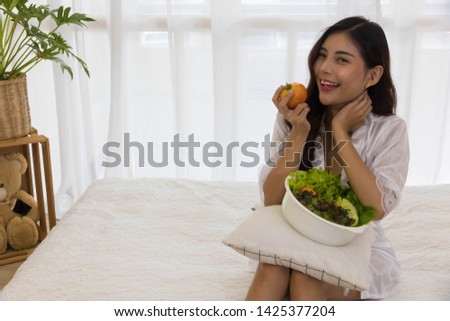 A Woman is holding lovely and healthy vegetables.