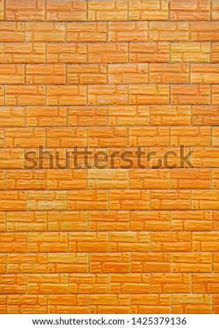 Coating of a wall with tiles imitating bricks backgound and texture, simple and cheap construction material