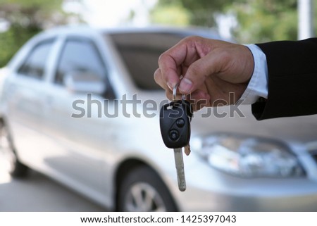  The car salesman and the key to the new owner.  
