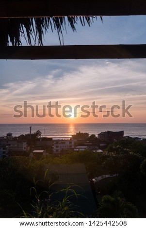 View of orange, yellow and blue sunset over Montanita beach town. Shot in Ecuador.