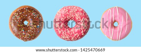 Different donuts on blue background. Minimal concept. Royalty-Free Stock Photo #1425470669