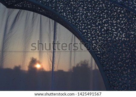scenery for an evening oriental wedding in the open air, metal arch, curtain,  sunset