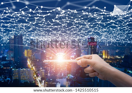 Hand holding smart on line connection network and city at night concept digital 5 G wireless with global communication. Royalty-Free Stock Photo #1425510515
