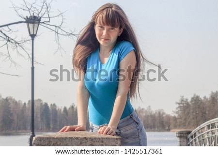 Girl in the spring in the park for a walk. The girl in the park. Walk in the park. in jeans and t-shirt.