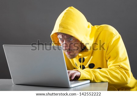 man in a yellow jacket working on the Internet. on gray background