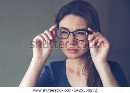 A woman with eyesight problems sees poorly through glasses. Astigmatism concept. Royalty-Free Stock Photo #1425538292