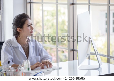 young  asian woman research scientist  preparing test tube and analyzing microscope With Computer in  Laboratory .