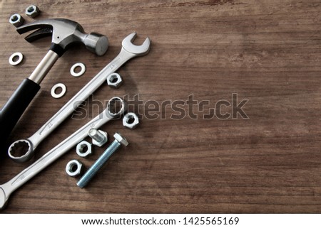 Tools. Wrenches, hammer and nuts on wooden background