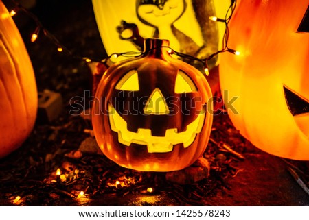 Scary Halloween decorations outdoors at night lighted