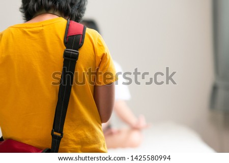 Asian woman in yellow shirt taking photos for her work. With copy space.