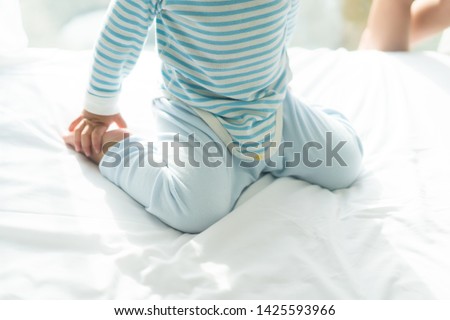 Baby Child sitting in the bad with W sitting position.W-sitting can cause to hip dislocation.body posture and bone care in Baby. Royalty-Free Stock Photo #1425593966