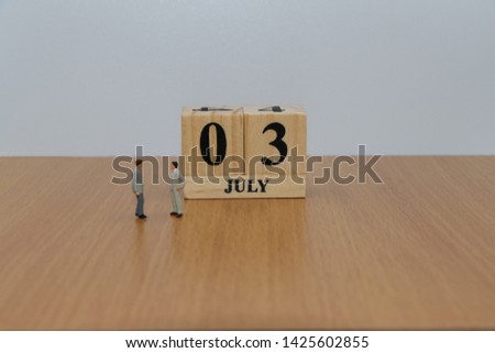 July 3, a calendar photo from the wood The table top consists of a book and pen that is ready to use. White background