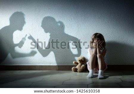 Little Girl Crying With Shadow Of Parents Arguing - Home Violence And Divorce Royalty-Free Stock Photo #1425610358