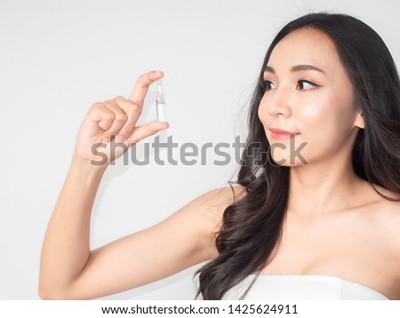 portrait asian beautiful woman.Closeup beauty skin face young girl holding serum bottle.isolated white background