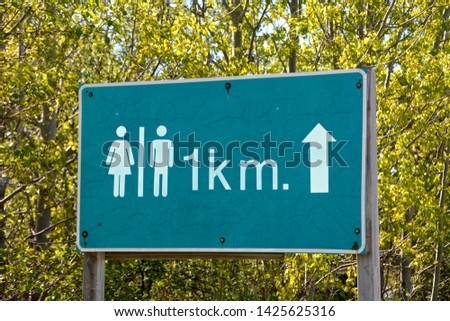 A graphics board shows the distance and the direction of the way to the toilets, green trees on a background.
