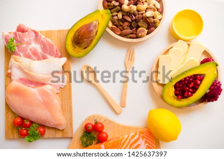 Intermittent fasting and Healthy food. Concept.Wooden spoon and fork and Keto diet food ingredients on white table. Ketogenic mean Low carb and High fat. 