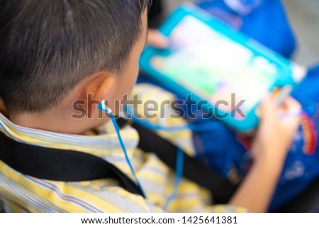 Asian boy child watching cartoon in tablet in sofa at home.child, technology and internet concept 