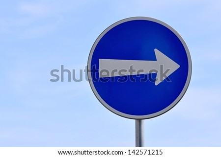 Blue road sign pointing direction on a light background
