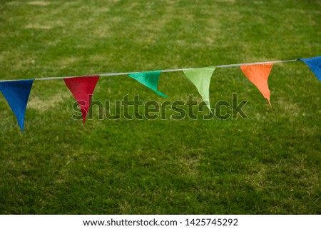 rope with multi-colored triangular flags to the fencing of the area in the wind outdoor