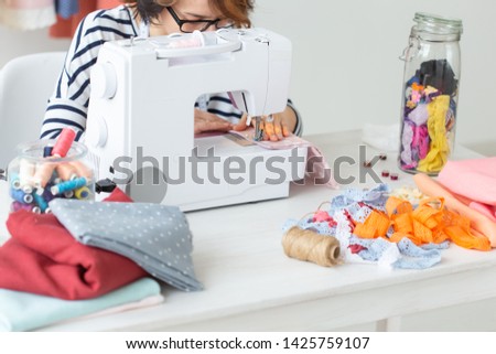 clothing designer, seamstress, people concept - woman seamstress working in her studio