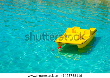 Yellow catamaran on the water. Pedal boat. Active rest on the water. Hobby. Leisure. Entertainment. Summer vacation. Royalty-Free Stock Photo #1425768116