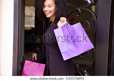 Beautiful young woman smiling holding colorful shopping bags
