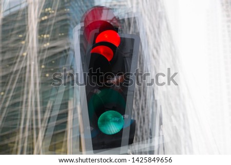 Traffic lights multiple exposure image. Traffic light showing red against of modern office block building. Business and modern life concept.  