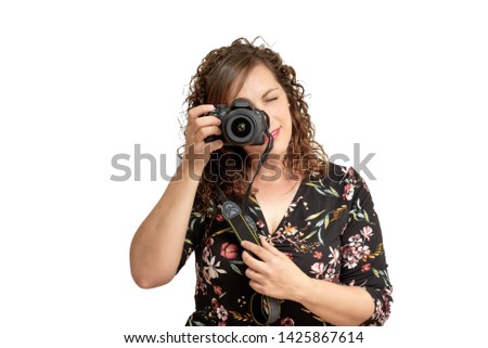Happy young woman taking a picture with a photo camera isolated over white background