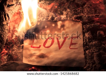 The fire burns a paper with an inscription love. Broken Heart. Relationship Concept