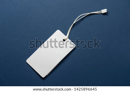 Blank tag tied with string. Price tag, gift tag, sale tag, address label isolated on blue background.