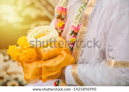 Buddhist Ordination. The man who want to become a monk will give garland to parent in order to apologize them. He wear a white shirt and already shave hair.   Royalty-Free Stock Photo #1425896990