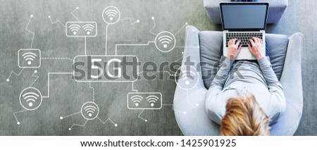 5G network with man using a laptop in a modern gray chair