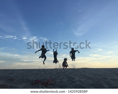 Silhouette of kids playing at the beach during sunset