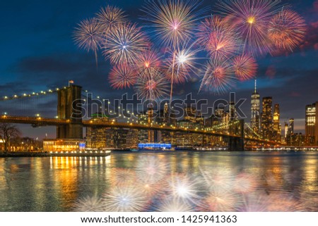Multicolor Firework Celebration over scene of New york Cityscape with Brooklyn Bridge over the east river at the twilight time, USA downtown skyline, 4th of July and Independence day concept