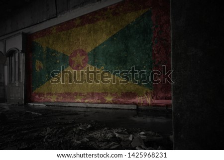 painted flag of grenada on the dirty old wall in an abandoned ruined house. concept