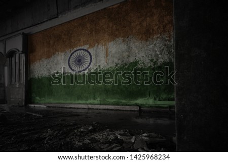 painted flag of india on the dirty old wall in an abandoned ruined house. concept