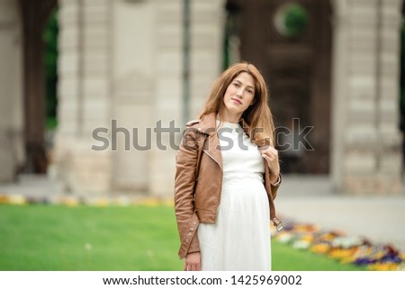 pregnant brunette woman with long hair. Woman at an old gazebo.