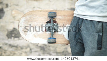 Caucasian boy with skateboard in his hand.