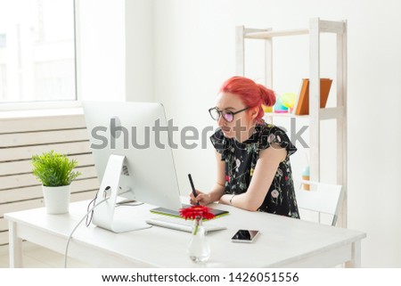 Graphic designer, animator and illustrator concept - young woman with red hair working at the laptop