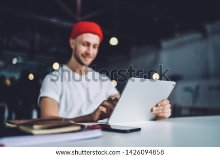 Millennial man holding digital tablet connecting to 4g wireless internet for networking websites during online communication with virtual friends, generation editor using application on touch pad