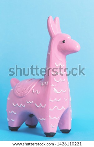 Pink zine type toy lama on a blue background close up. Creative and fun trendy collage animal concept with copy space