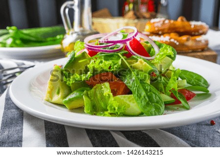 The salad with an avocado and tomatoes on a striped napkin