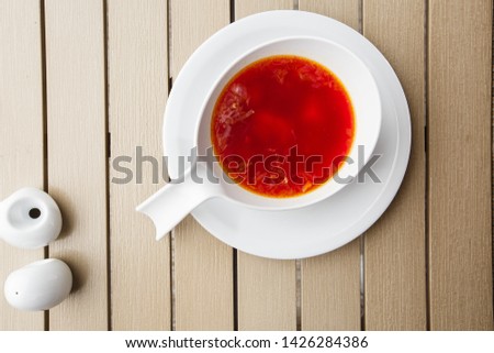 Top view Borscht, ukrainian cuisine sour soup, with meat, potato, beetroots. food background. Red soup in bowl with copy space for design. photo for menu