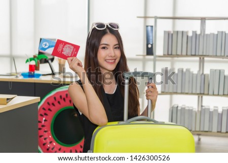 Beautiful Asian business woman smiling holding passport and ticket  with yellow suitcase to prepare traveling for travel tourist on holiday weekend. Business and travel concept.