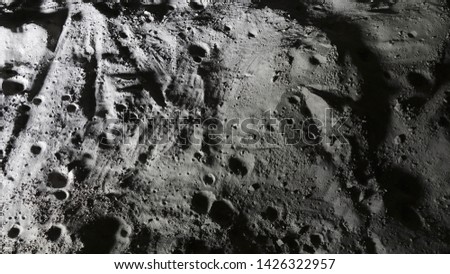 Miniature scale model of the Moon surface with its craters, shoot in the studio set under small led lights, with wide angle lens.
