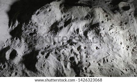 Miniature scale model of the Moon surface with its craters, shoot in the studio set under small led lights, with wide angle lens.