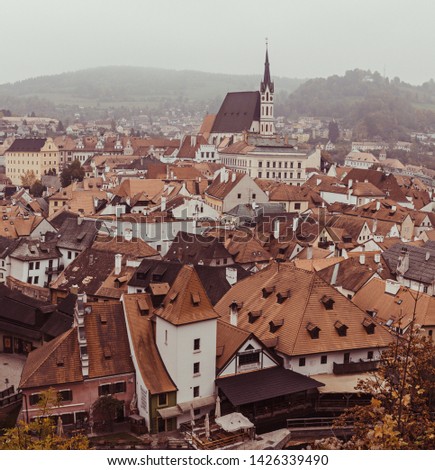 Cesky Krumlov - a famous czech historical beautiful town from above, travel background with red roofs and chapel